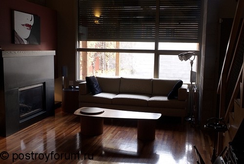Обскурная гостиная с маленким диваном и камином.